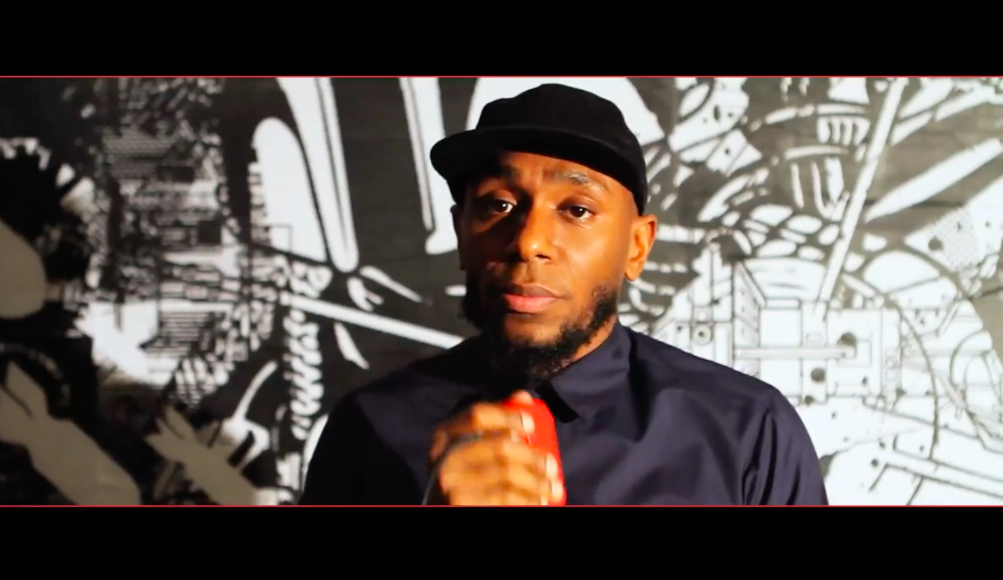Yasiin Bey holding red microphone
